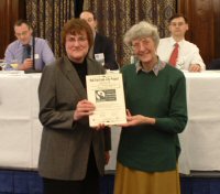 Dorothy Vinegrad (left) receiving the certificate from Chris Church